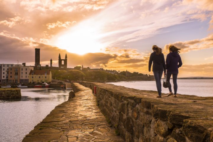students walking on the pier at sunset